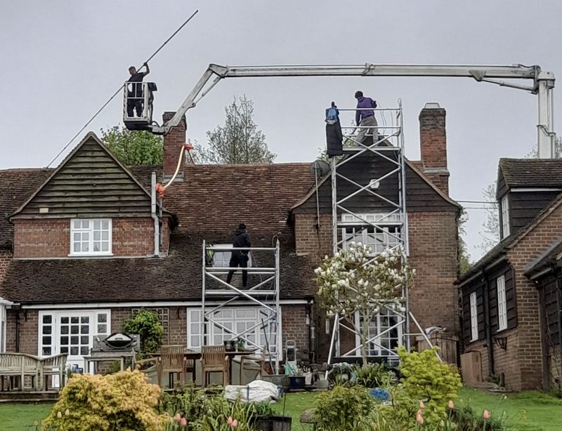 The Moss Cleaners using cherry picker and scaffolding to clean roof safely and professionally in Egham, Surrey